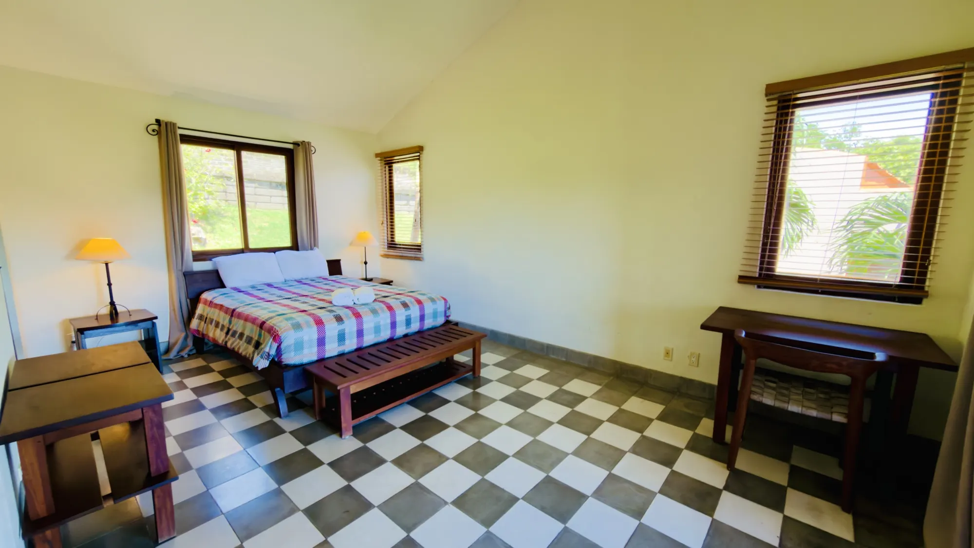 Bedroom with a queen bed and windows onto the garden