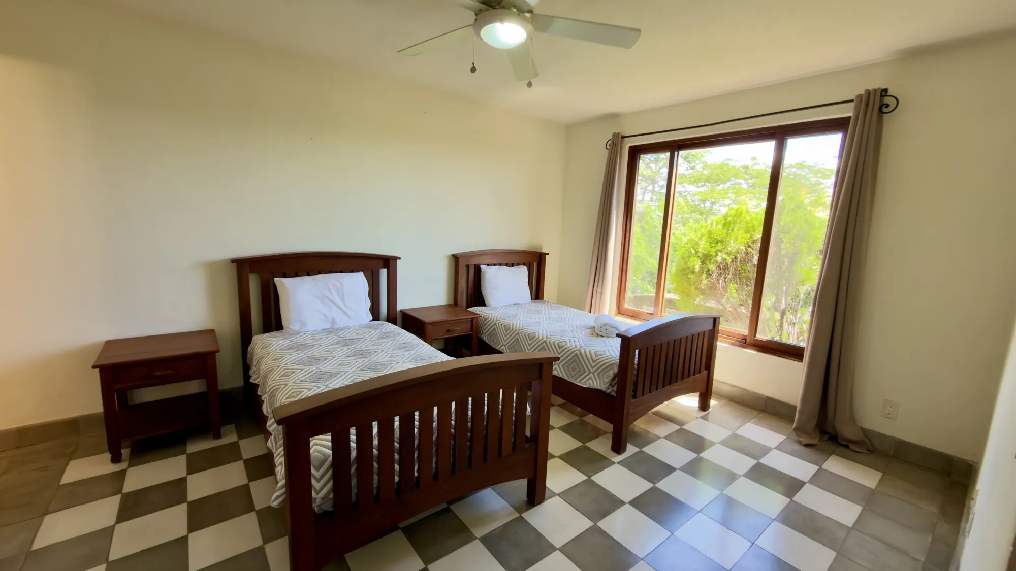 Bedroom with two twin beds and a large window onto the trees