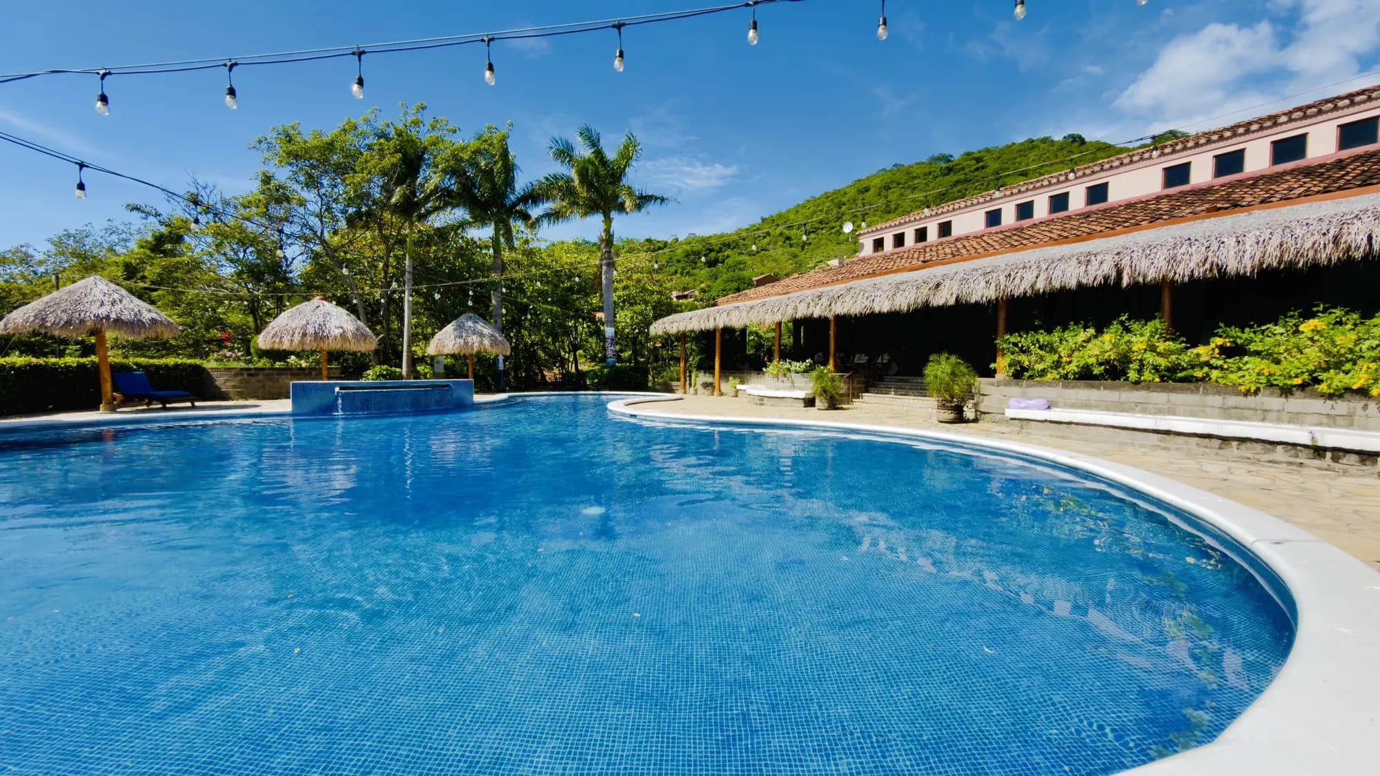 The pool under string lights on a clear day