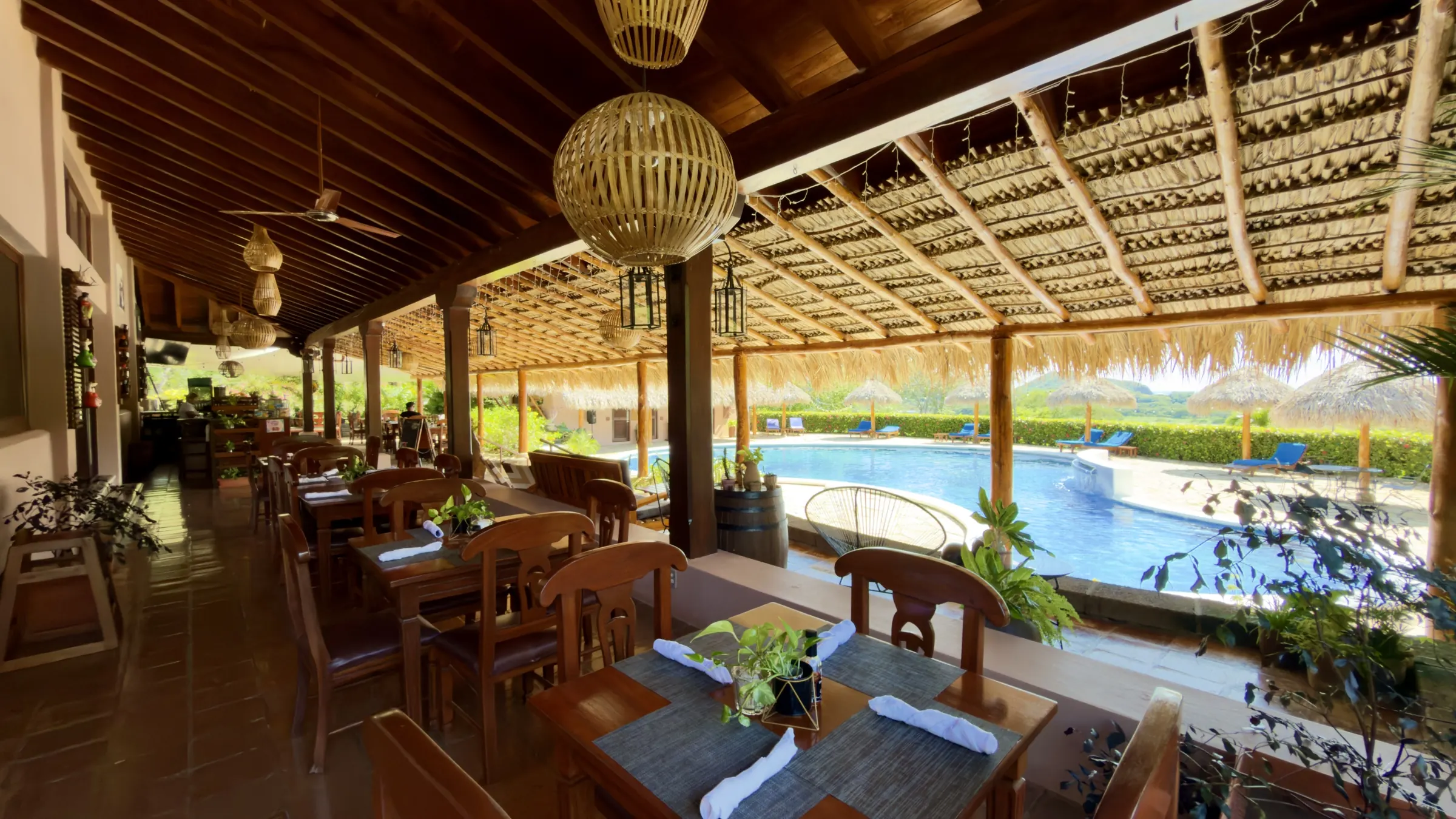 Terraza de Palermo's tables under the palapa roof, facing the pool