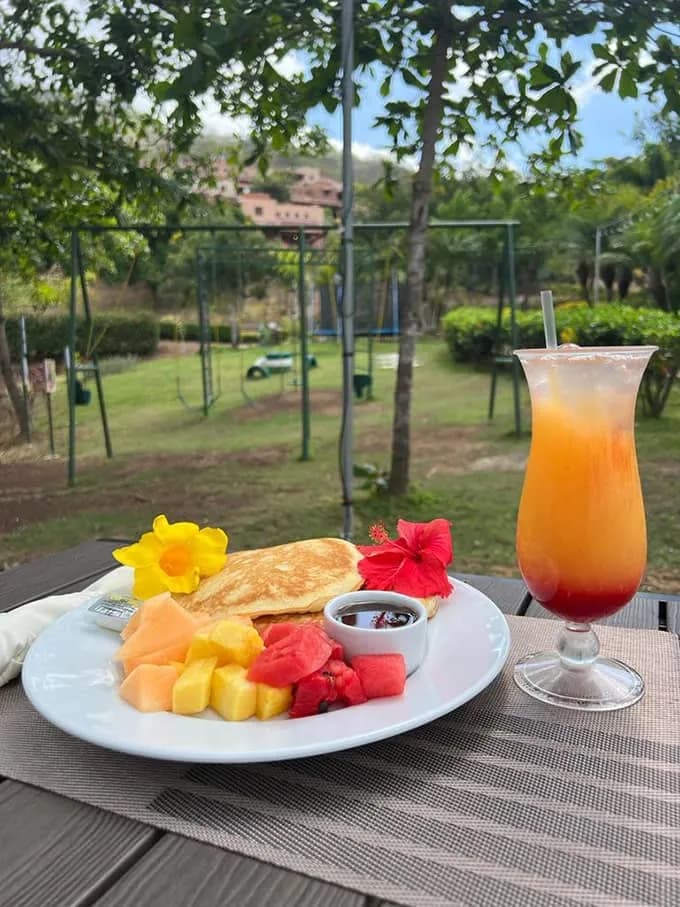 Plato de desayuno con fruta fresca y un jugo