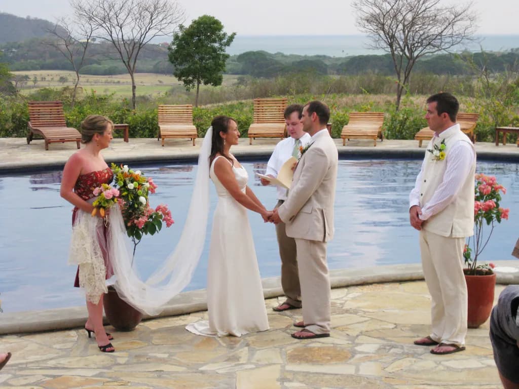 Una pareja diciendo sus votos junto a la piscina del resort