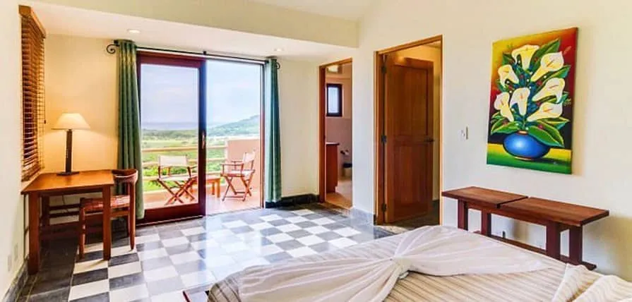 Una habitación que abre a un balcón con vista a la bahía